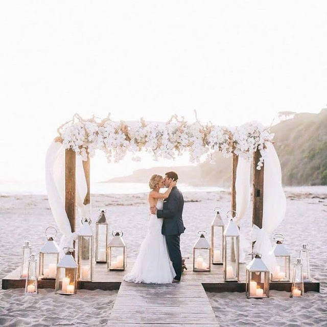 Top 20+ Romantic Beach Wedding Decor Ideas for Your Big Day Aliens tips Beach Wedding Decor Ideas, Romantic Beach Wedding, Starfish and Shells, Hanging Decorations, Bamboo Arch, Wooden Signs, Beach Umbrellas, Wooden Slice Centerpieces, Seashell Escort Cards, Driftwood Decor, Fairy Lights, Flower Garlands, Seaside-Inspired Favors, Beachy Escort Card Display, White Linens, Nautical Details, Seashell Bouquets, Wooden Benches, Sand-Filled Vases, Ocean-Inspired Invitations, Beachy Table Numbers, Sunset Serenade.